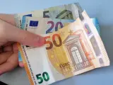 Imagen de archivo de una persona sosteniendo 75 euros.