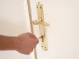 Archivo - Un hombre introduce una llave en la cerradura de la puerta de una vivienda.