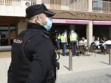 Un agente de la Policía Nacional durante un control a una terraza de un restaurante de Palma de Mallorca (España), a 6 de marzo de 2021. El pasado 3 de marzo, entraron en vigor medidas para la desescalada en Mallorca,