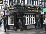 Una persona con mascarilla apoyada en la puerta de un pub cerrado en Londres este jueves.