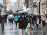 Varios peatones con paraguas en el centro de Madrid.