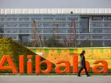 Un empleado pasa por delante del logo de Alibaba en su sede central en Hangzhou (China).