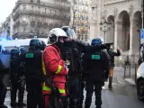 Archivo - Un bombero junto a agentes de la Policía en París durante las manifestaciones contra la reforma de las pensiones.