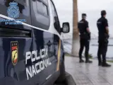 Archivo - Agentes de la Policía Nacional junto a un coche patrulla