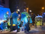 Médicos y sanitarios del SAMUR-Protección Civil atienden a uno de los heridos por arma blanca en una reyerta ocurrida en el distrito de Usera, en Madrid.