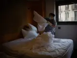 Una camarera de pisos cambia las sábanas de una cama de una habitación del Hotel Claris, en Barcelona.