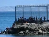 Un grupo de migrantes marroquíes en las inmediaciones de la valla de Ceuta