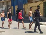 Un agente de la policía nacional junto a varios de los inmigrantes que han llegado a nado este lunes a Ceuta.