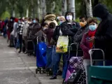 Gente espera en las llamadas 'colas del hambre' en Aluche (Madrid).
