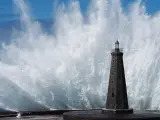 Una gran ola rompiendo contra la costa.
