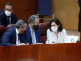 Isabel Díaz Ayuso (d) conversa con los diputados del PP Enrique López (i) y Enrique Matias Ossorio Crespo (2i) durante la segunda jornada del debate de investidura en Madrid.