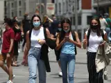 Varias personas caminan con mascarilla por Madrid en junio de 2021.