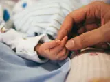 Madre coge la mano de su bebé.