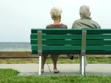 Una pareja de ancianos, sentados en un banco.