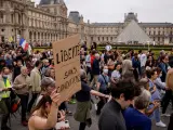 Manifestantes pasan junto a la pirámide del Louvre para protestar contra el pasaporte de vacunación de la Covid-19.