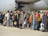Decenas de afganos recién llegados a España hacen cola en la base de Torrejón de Ardoz.