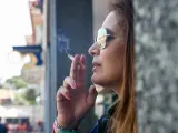 Una mujer fumando un cigarro.