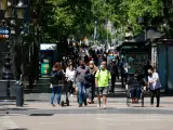Personas pasean por la Rambla, en Barcelona.