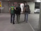 G.O.O, el estadounidense detenido, acompañado de dos agentes de la Guardia Civil tras su detención en Barcelona.