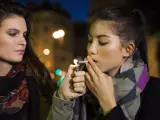 Una joven fuma un porro.