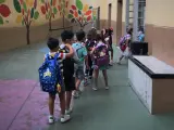Niños con mascarilla entrando en un colegio