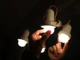 Una persona cambia la bombilla de una lámpara.