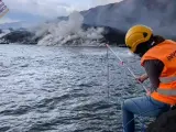 Trabajadora de Involcan grabando el sonido de la lava cayendo al mar