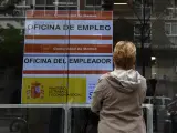 Una mujer observa un anuncio de una Oficina del Servicio Público de Empleo Estatal (SEPE).