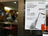 Un cartel en un bar avisa de que hay que mostrar el pasaporte Covid.