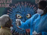 Una sanitaria india realiza un test de Covid a un pasajero de Bangalore tras la detección de la variante ómicron del coronavirus en el estado de Karnataka, India.