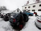 Dos personas empujan un vehículo que ha quedado atrapado en la nieve en el parking de Roncesvalles este domingo.
