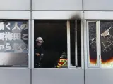 Bomberos inspeccionan un edificio en Osaka, Japón, tras un incendio en la cuarta planta del inmueble en el que pudieron haber fallecido al menos 27 personas.