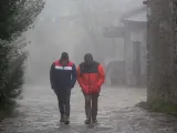 Dos hombres caminando entre la niebla en Lugo.