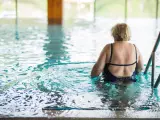 Mujer entra en la piscina del balneario para tratar su osteoporosis