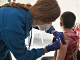 Una sanitaria vacuna a un niño en un colegio de Córdoba.