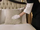 Una persona limpia una habitación de hotel en una imagen de archivo.