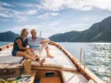 Pareja disfruta de las vistas en un velero a través del lago Lugano, en Suiza