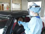 Una enfermera realiza una prueba PCR en el punto autocovid del antiguo Hospital Militar de Sevilla.