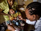 Una sanitaria atiende a un bebé en África