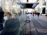 Dos personas con mascarilla esperan el autobús en Madrid, el 11 de enero de 2022.
