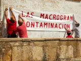Varios vecinos cuelgan una pancarta contra las macrogranjas en Espinosa de Villagonzalo (Palencia).