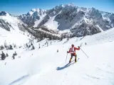 Un hombre hace esquí de travesía en las montañas sobre la nieve, explorando los Dolomitas.