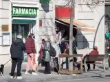 Varias personas guardan cola ante una farmacia del barrio del Guinardó, en Barcelona, que vende y realiza test de antígenos.