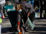 Una mujer recoge los productos de alimentación donados por parte de la Despensa Solidaria de Chamberí durante la concentración y reparto de alimentos a familias vulnerables, en Madrid (España), a 13 de marzo de 2021.