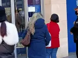 Personas mayores esperando para utilizar un cajero automático de un banco en Barcelona.