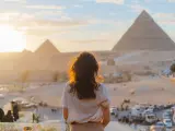 Mujer de pie en la terraza sobre el fondo de las pirámides de Guiza.