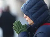 Una mujer se frota las manos por el frío.