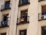 Un cartel de 'se alquila' cuelga de un balcón en la fachada de un edificio madrileño