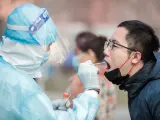 Un sanitario realiza un test a un ciudadano en Pekín