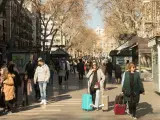 Turistas portando maletas circulan este jueves 27 de enero de 2021 por La Rambla de Barcelona.